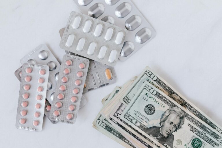 different pill blisters near pile of american dollar banknotes